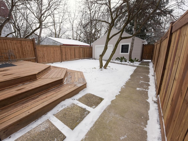 snowy yard featuring an outbuilding and a fenced backyard