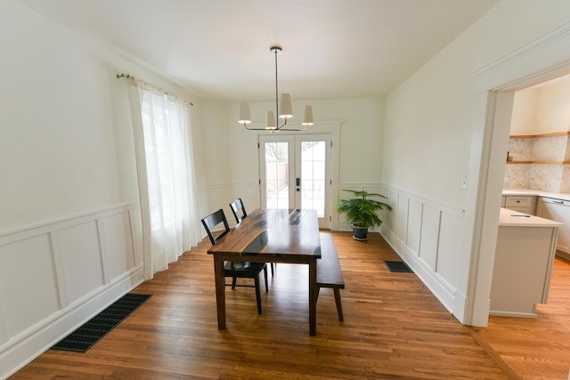 dining room featuring a chandelier, french doors, wood finished floors, and visible vents