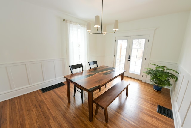 dining space featuring visible vents, wood finished floors, and french doors