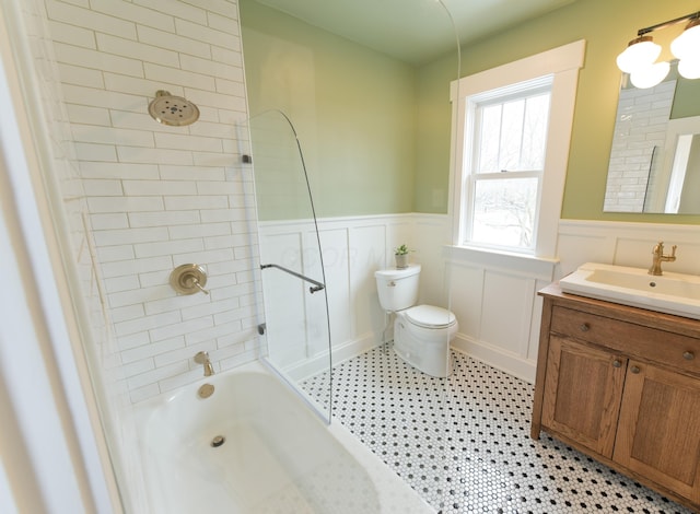 full bath featuring wainscoting, vanity, toilet, and shower / bathtub combination