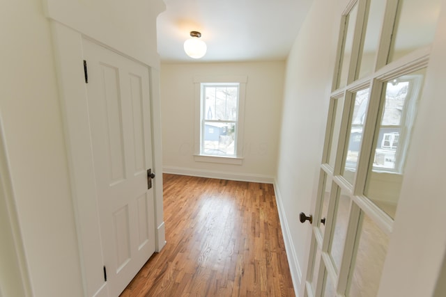 doorway with wood finished floors and baseboards