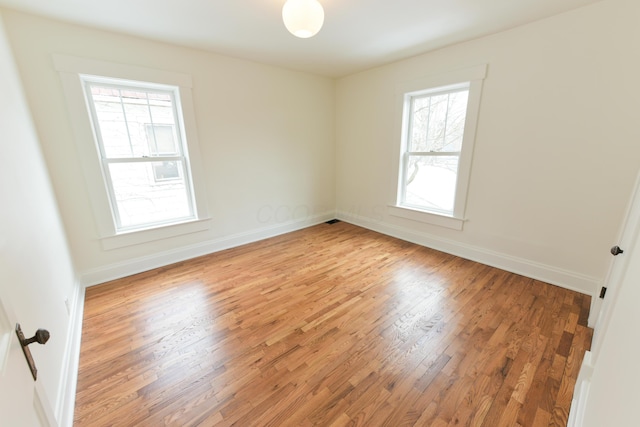 spare room with light wood finished floors and baseboards