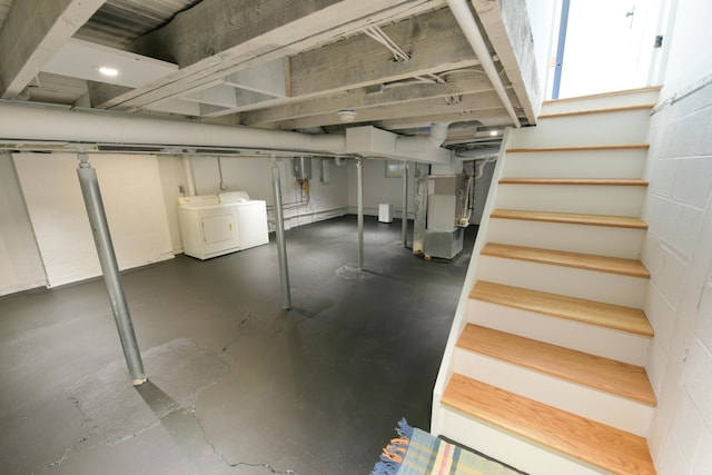 basement featuring washer and dryer, concrete block wall, stairway, and heating unit