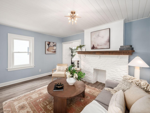 living area with a fireplace, wood finished floors, wooden ceiling, and baseboards