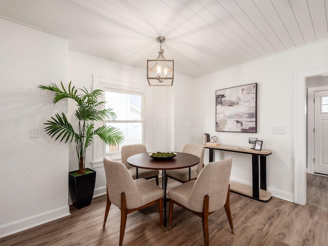 dining room with a chandelier, wood finished floors, wood ceiling, and baseboards