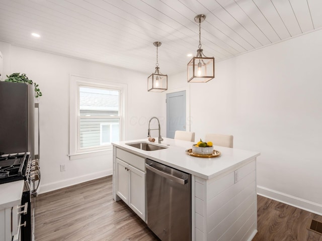 kitchen with dark wood-style flooring, a sink, white cabinetry, dishwasher, and decorative light fixtures