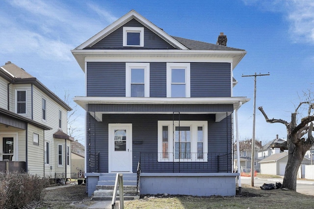 american foursquare style home with covered porch and a chimney