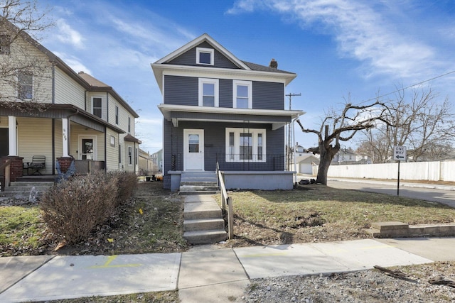 american foursquare style home with a porch and fence