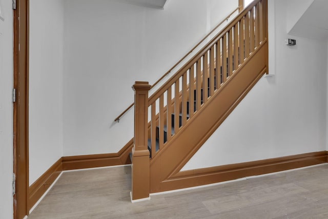 stairway with baseboards and wood finished floors