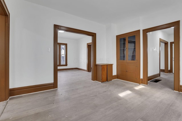 empty room featuring light wood-style flooring and baseboards