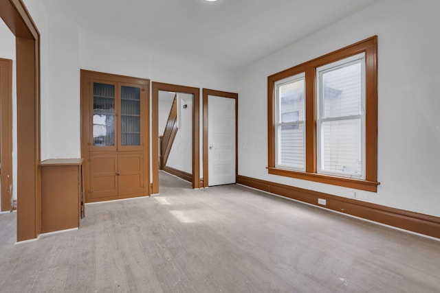 empty room featuring light wood-style flooring and baseboards