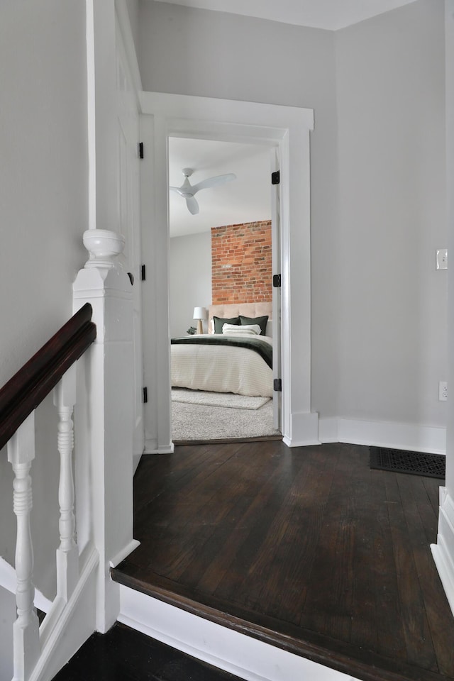 hall featuring wood-type flooring and baseboards