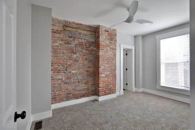 empty room featuring carpet floors, visible vents, baseboards, and a ceiling fan