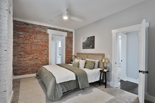 bedroom with ceiling fan, brick wall, and baseboards