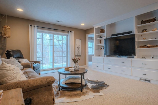 carpeted living room with visible vents, recessed lighting, and baseboards