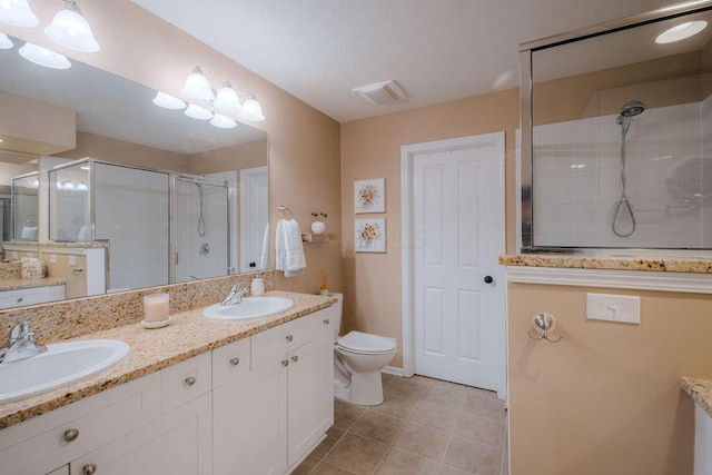 bathroom with a sink, visible vents, a stall shower, and tile patterned floors