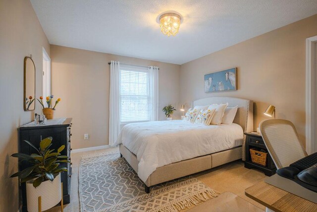 bedroom with light colored carpet and baseboards