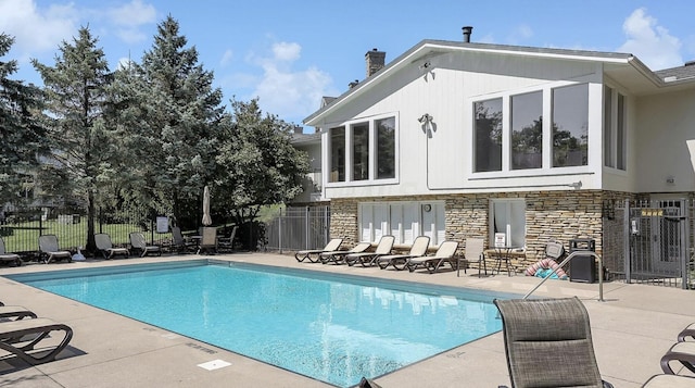 pool with a patio and fence