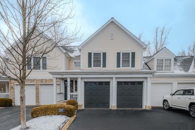 traditional-style house featuring stone siding and driveway