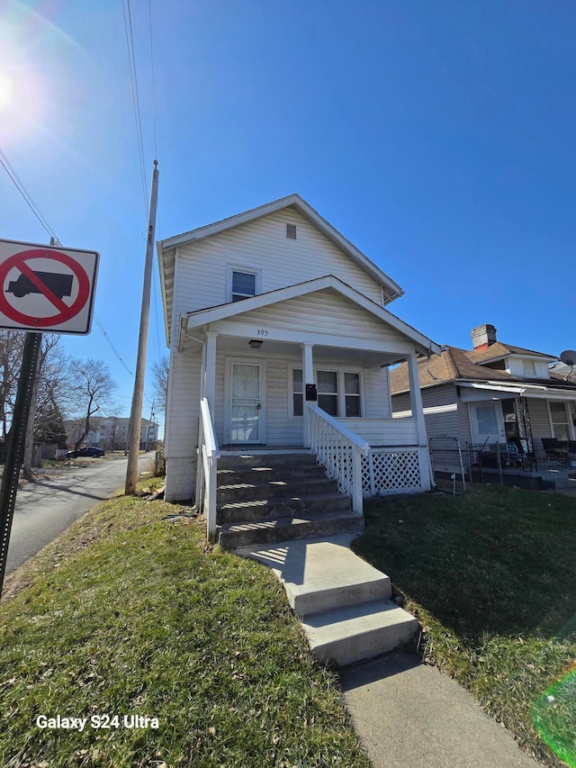 view of front of house with a porch and a front yard