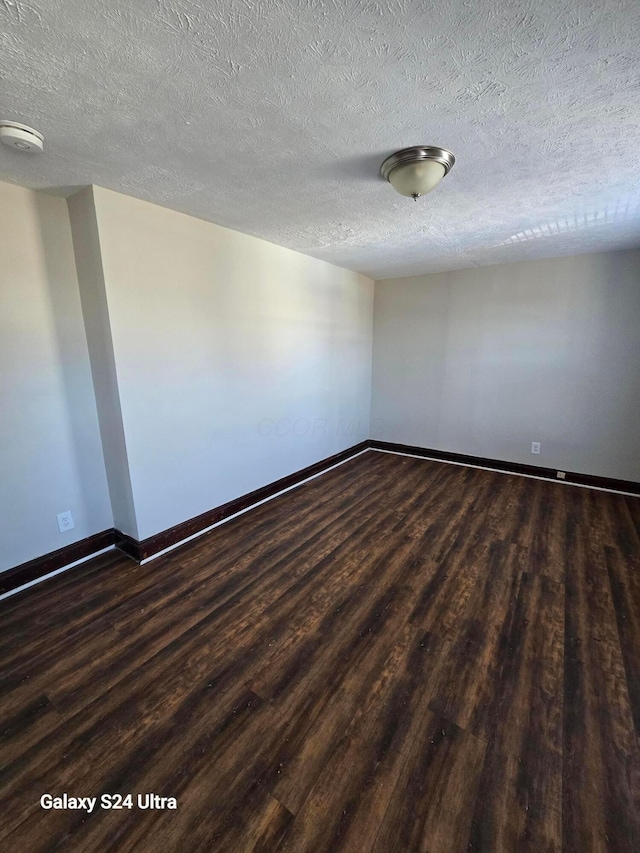 spare room featuring baseboards, a textured ceiling, and wood finished floors