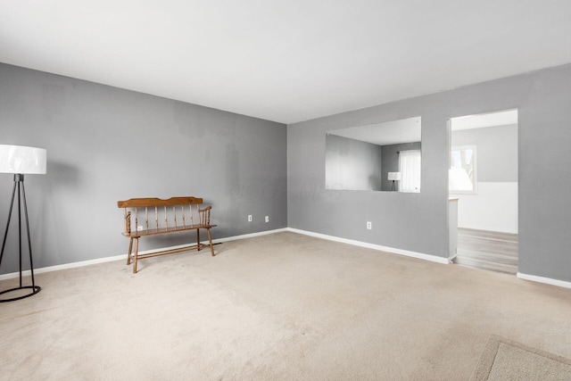 unfurnished room featuring carpet and baseboards