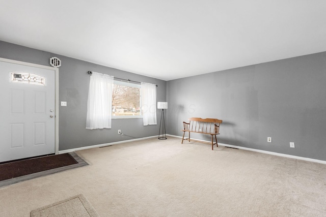 foyer entrance with carpet, visible vents, and baseboards