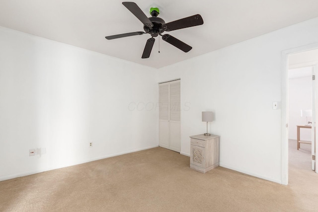 unfurnished bedroom with light carpet, ceiling fan, a closet, and baseboards