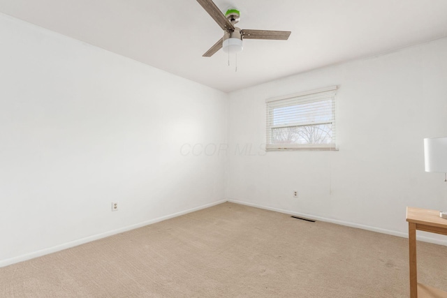 unfurnished room featuring baseboards, visible vents, ceiling fan, and light colored carpet