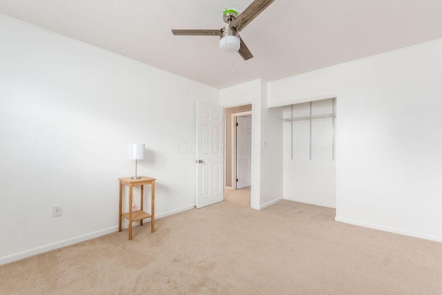 unfurnished bedroom featuring ceiling fan, baseboards, a closet, and light colored carpet