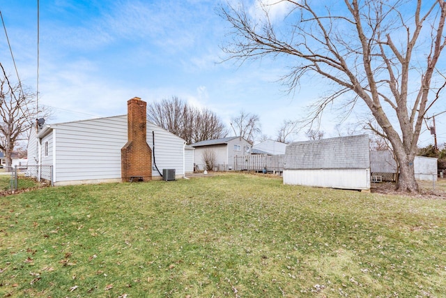 view of yard with an outbuilding, a storage shed, cooling unit, and fence