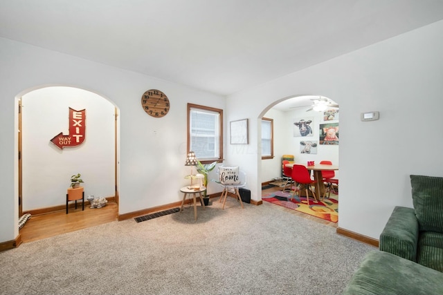 recreation room featuring arched walkways, carpet floors, visible vents, and baseboards