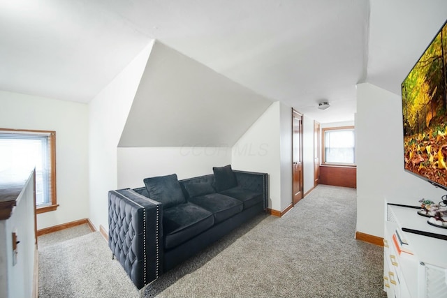 carpeted living room with vaulted ceiling and baseboards