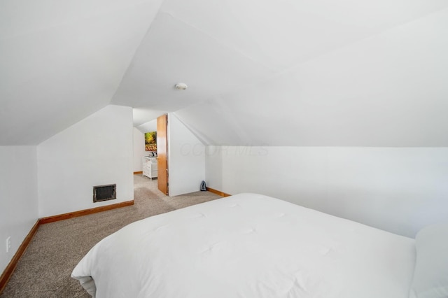 carpeted bedroom with lofted ceiling, heating unit, and baseboards