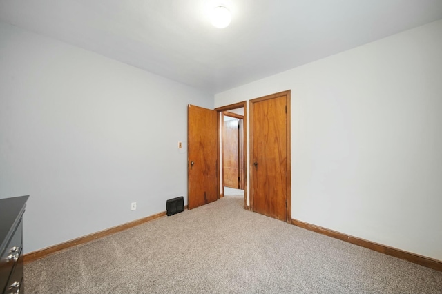 unfurnished bedroom with carpet flooring and baseboards