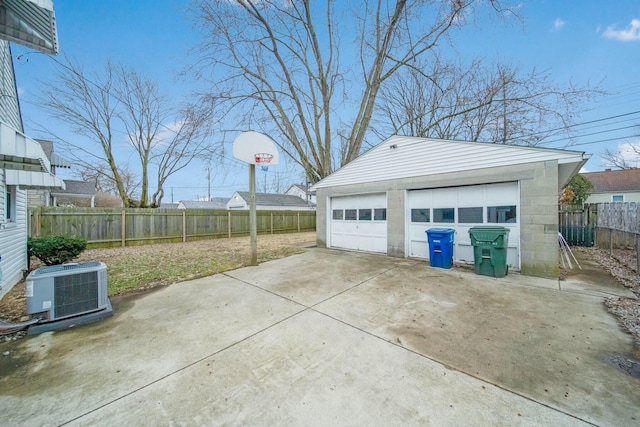 detached garage with fence and central AC unit