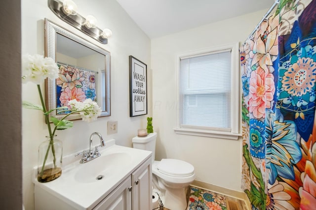 bathroom with toilet, curtained shower, and vanity