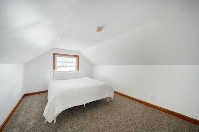 bedroom featuring vaulted ceiling, carpet flooring, and baseboards