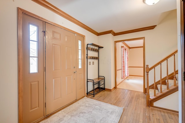 entryway featuring stairs, light wood finished floors, baseboards, and crown molding