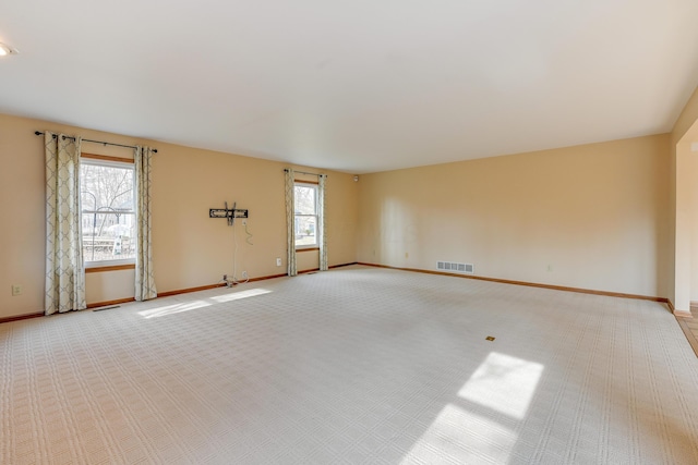 empty room with light carpet, baseboards, and visible vents