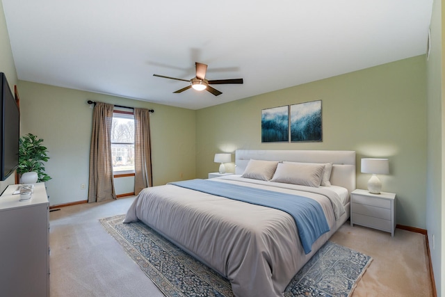 bedroom with light carpet, ceiling fan, and baseboards