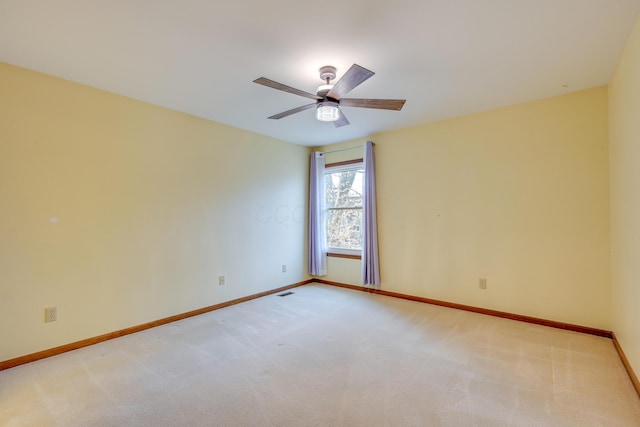 empty room with light carpet, ceiling fan, and baseboards