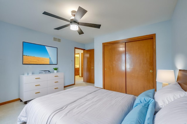 bedroom with a closet, visible vents, a ceiling fan, light carpet, and baseboards