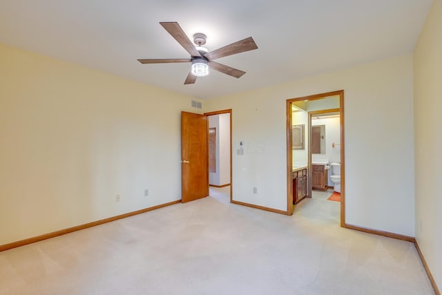 unfurnished bedroom with light colored carpet, visible vents, a ceiling fan, ensuite bath, and baseboards