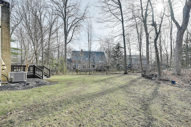 view of yard featuring fence, central AC unit, and a wooden deck