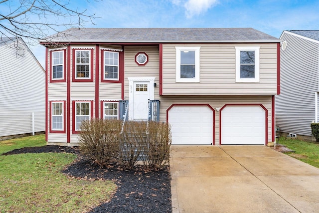 bi-level home featuring a garage, driveway, and a shingled roof