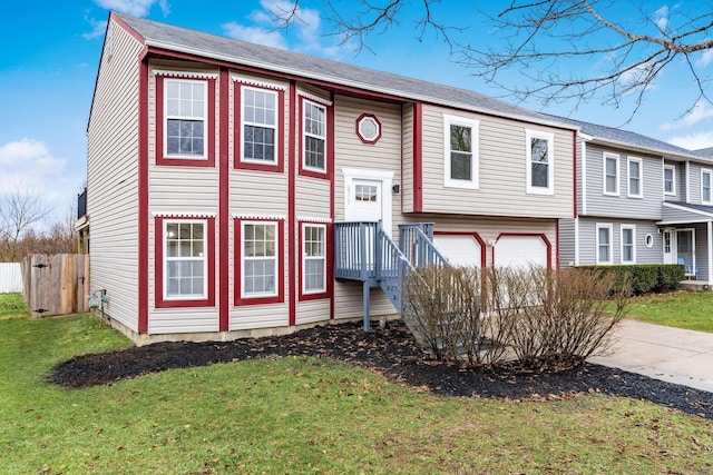 bi-level home with a garage, a front yard, and concrete driveway