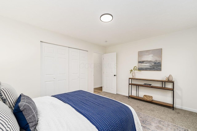 carpeted bedroom featuring a closet and baseboards