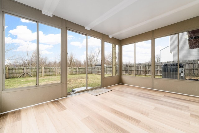 unfurnished sunroom with beam ceiling