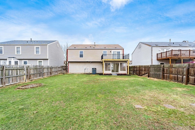 rear view of house with a fenced backyard, central AC unit, and a lawn